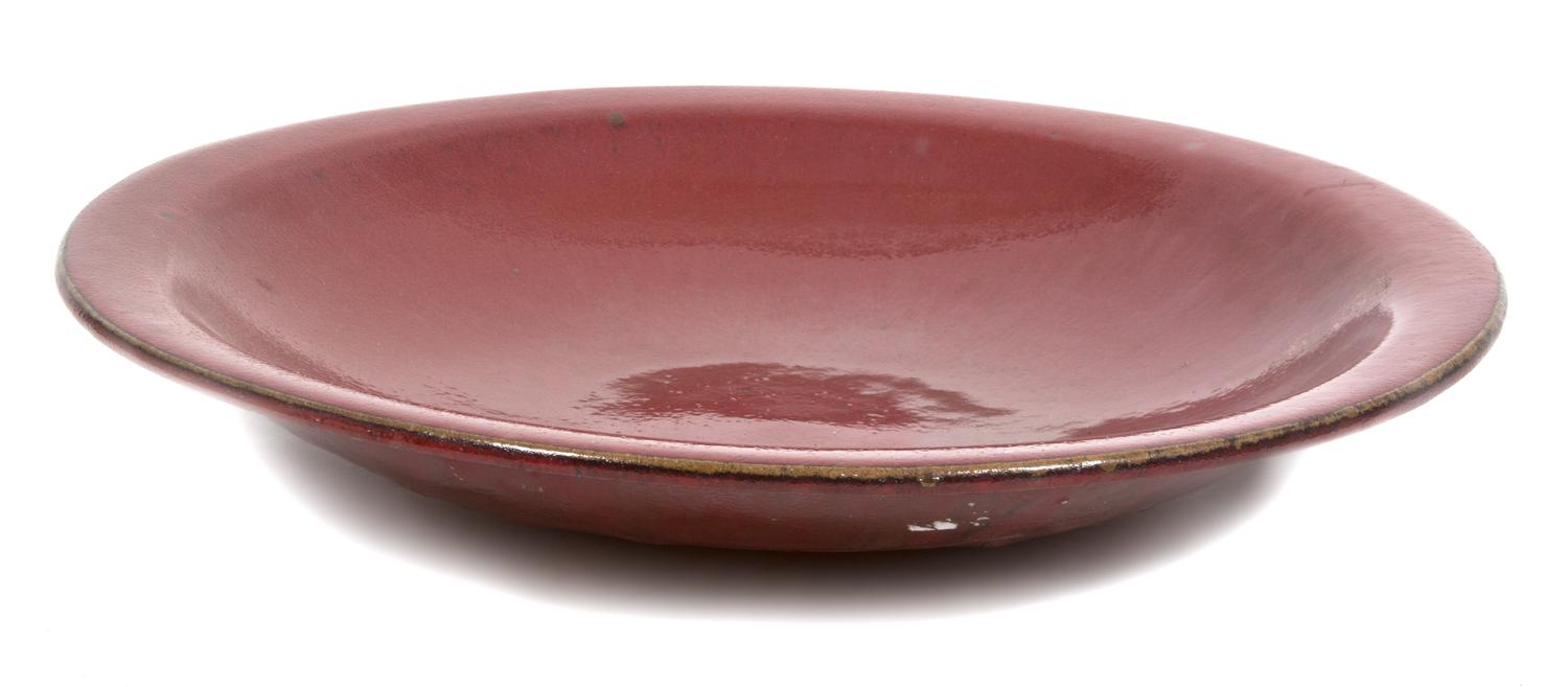 A Red Glazed Ceramic Charger Diameter 20 inches. — 20TH CENTURY