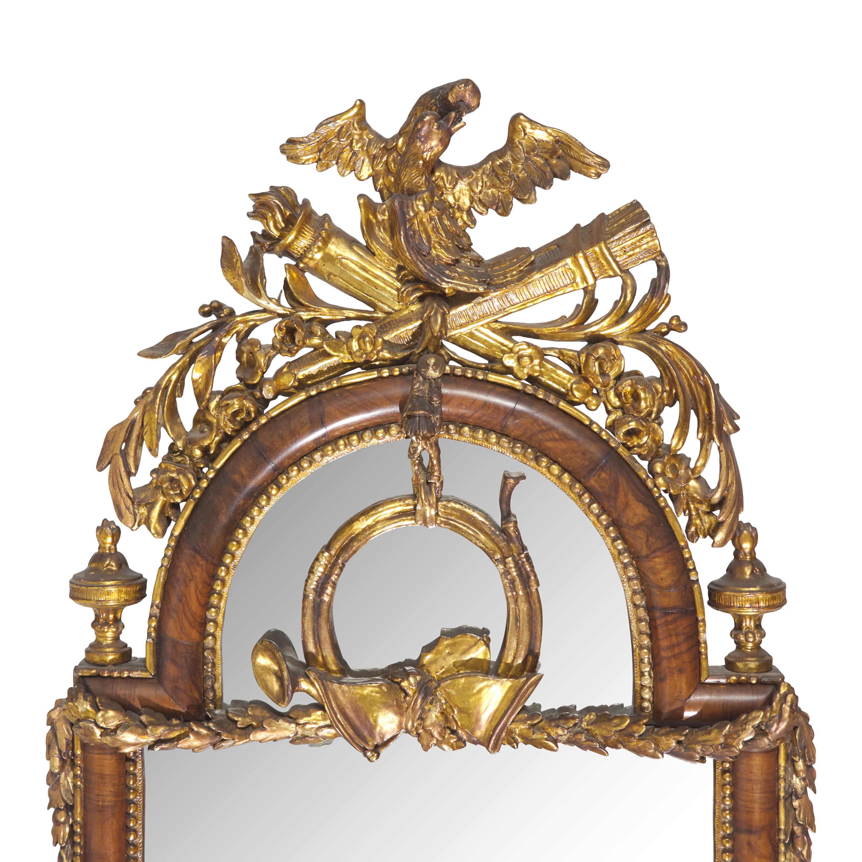 A Pair of Neoclassical Parcel Gilt Walnut Eagle-Decorated Looking Glasses