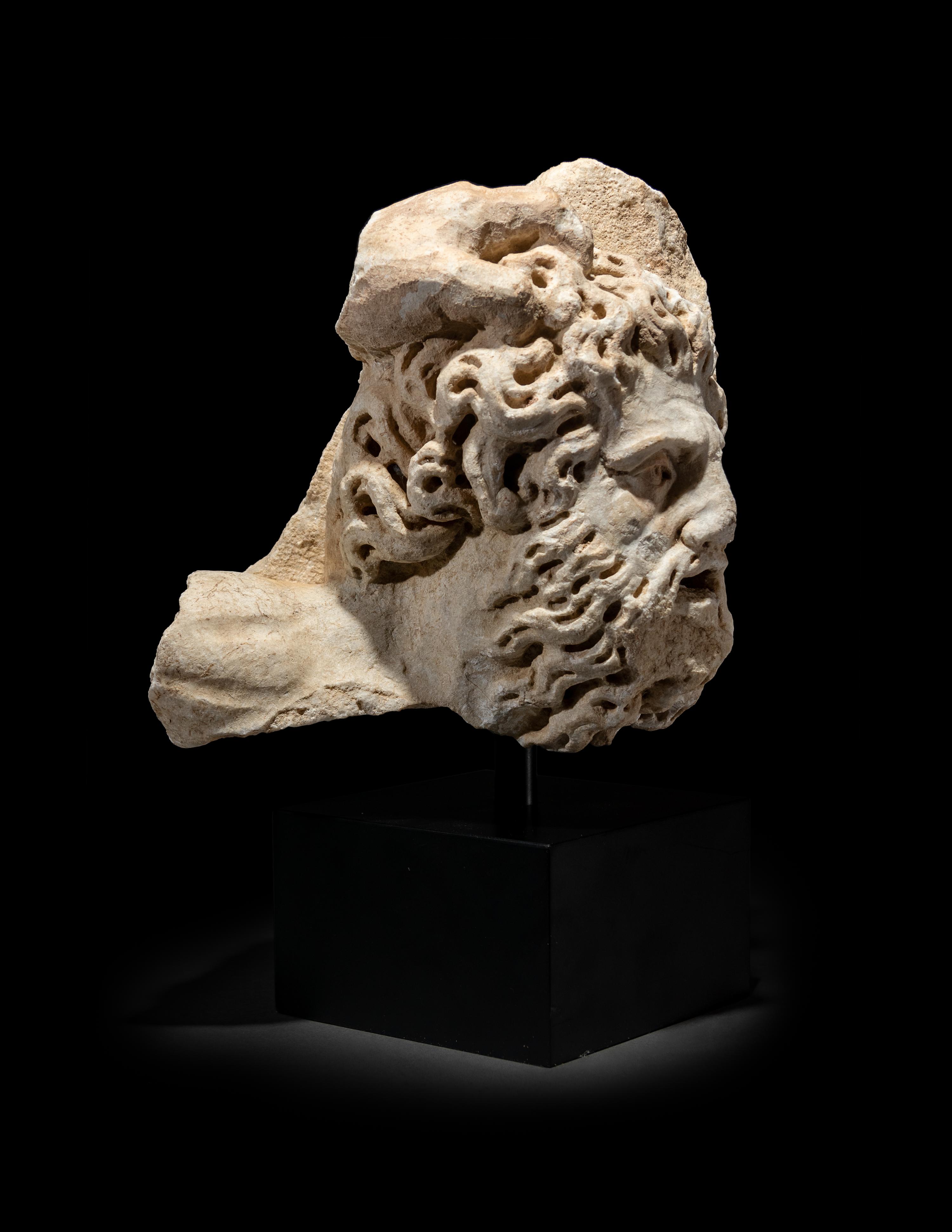 A Roman Marble Bearded Head, Perhaps a Giant, from a Relief