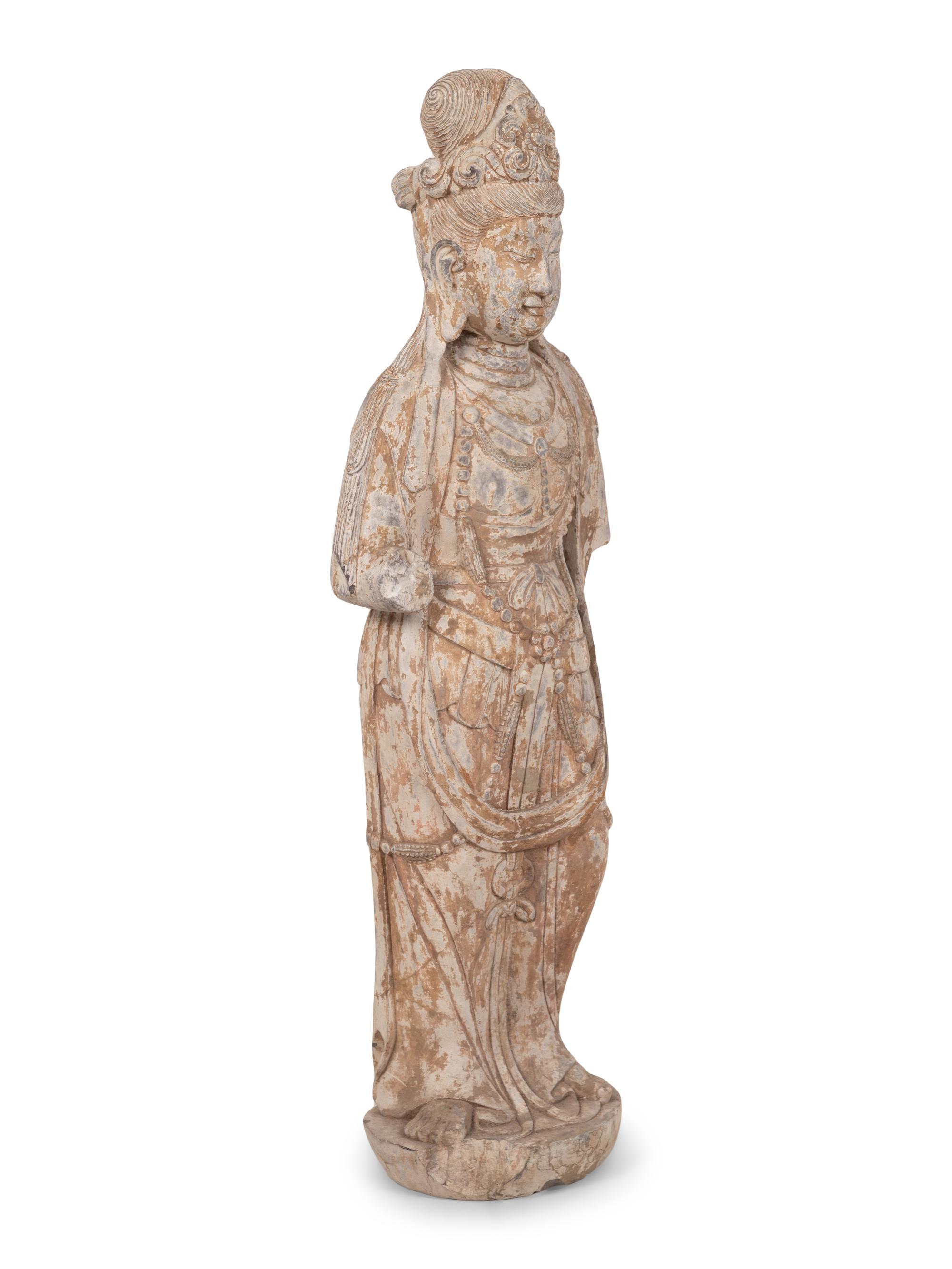 A Chinese Carved Stone Standing Guanyin Figure with Remnants of Polychrome Decoration