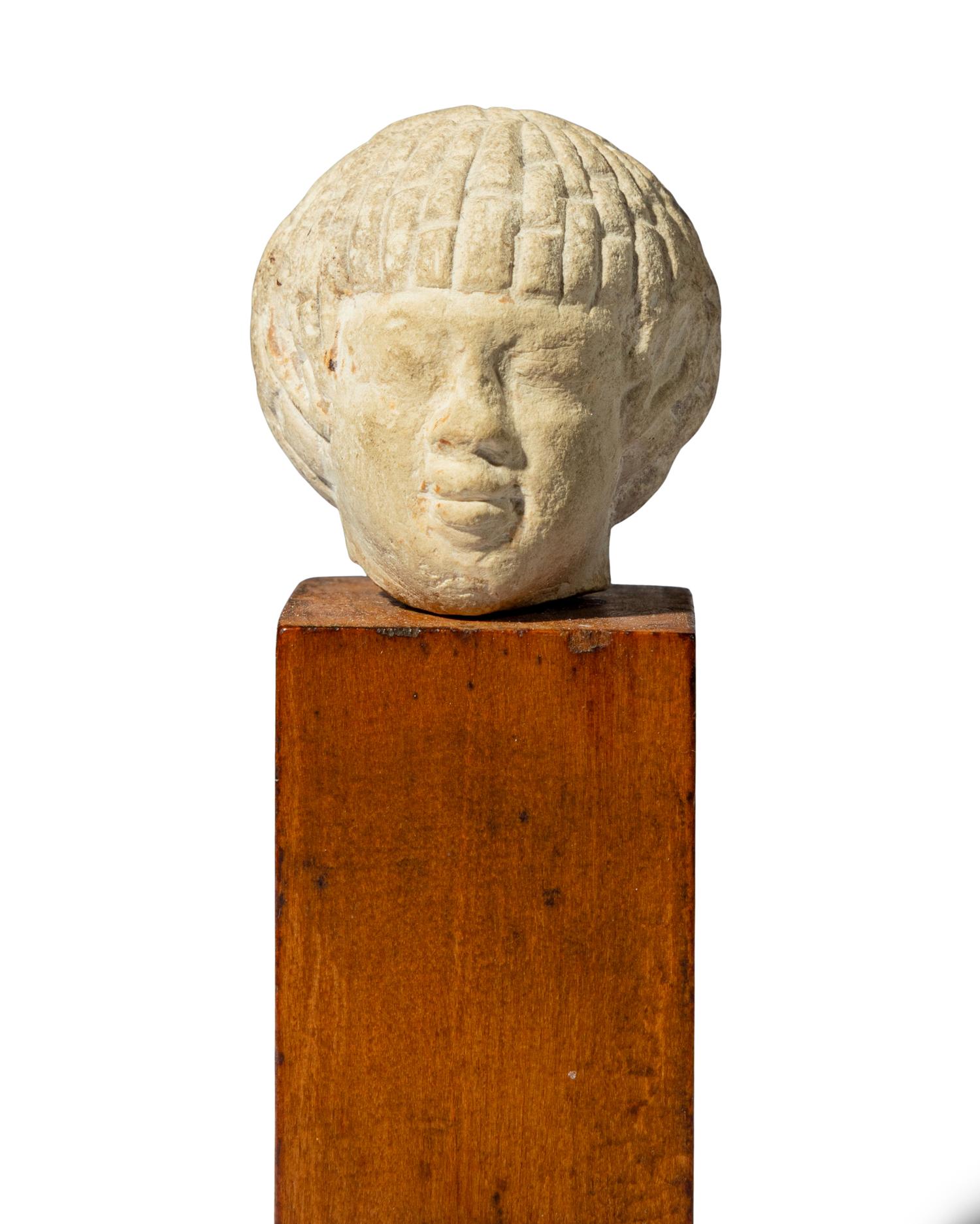 An Egyptian Limestone Head of a Nubian