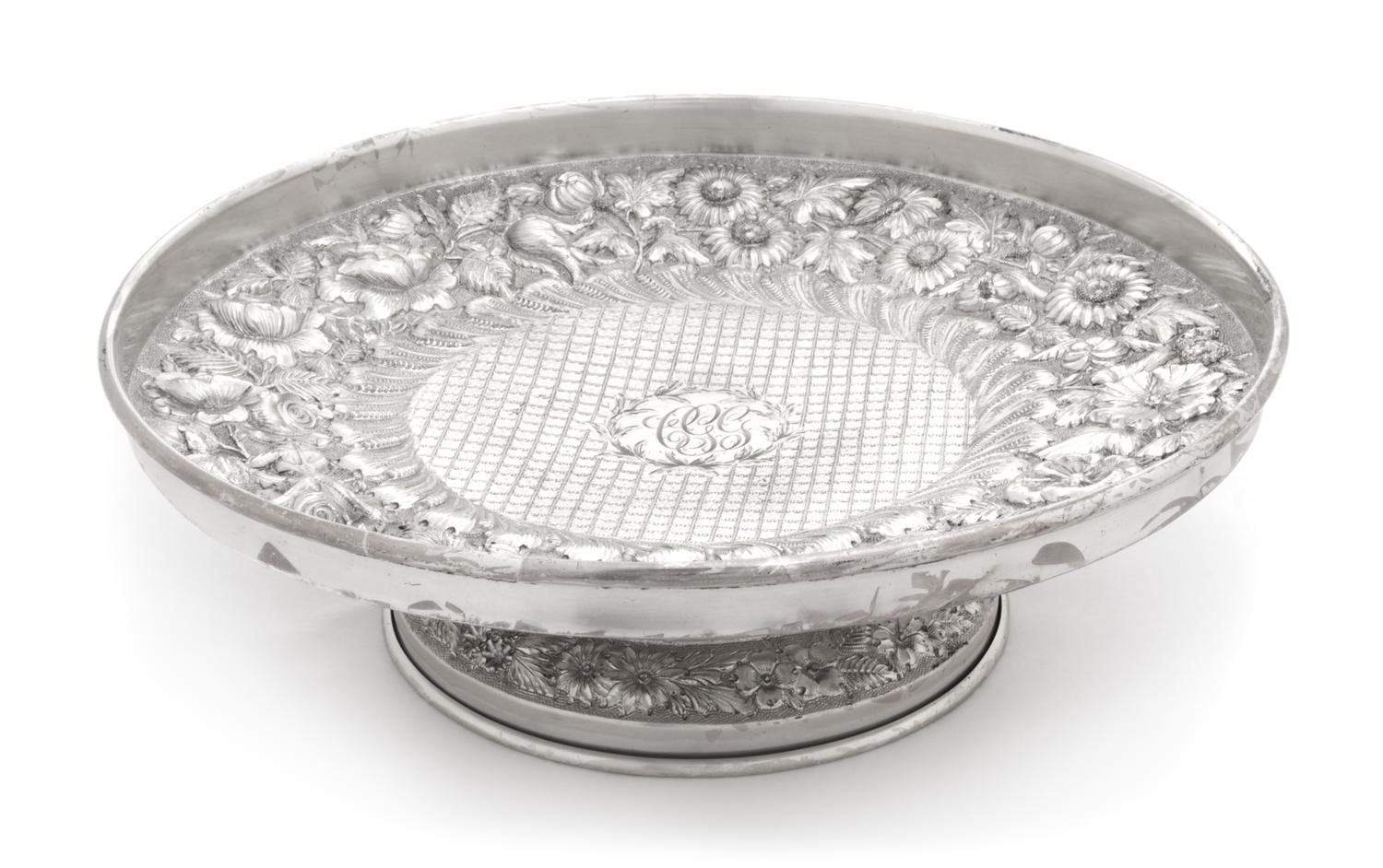An American Silver Cake Stand, F. Bucher & Sons, Baltimore, MD, having allover floral and foliate repousse decoration and centered by a