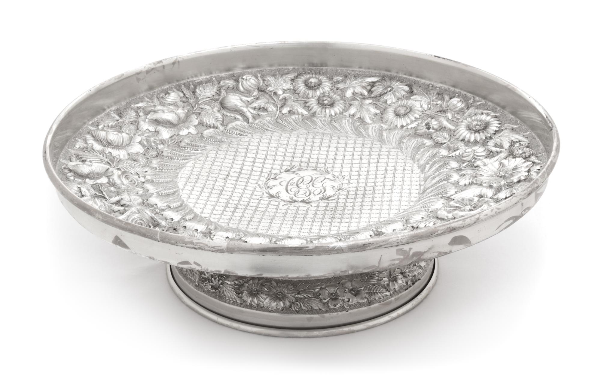 An American Silver Cake Stand, F. Bucher & Sons, Baltimore, MD, having allover floral and foliate repousse decoration and centered by a