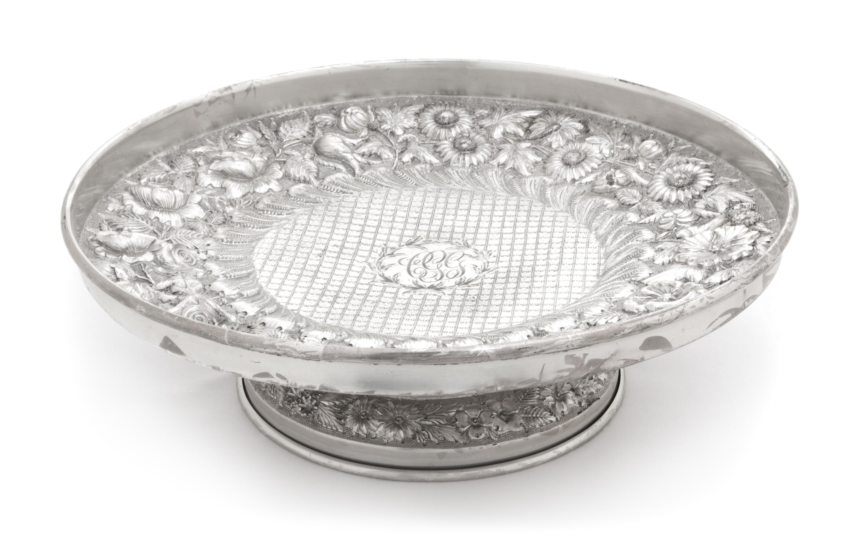 An American Silver Cake Stand, F. Bucher & Sons, Baltimore, MD, having allover floral and foliate repousse decoration and centered by a
