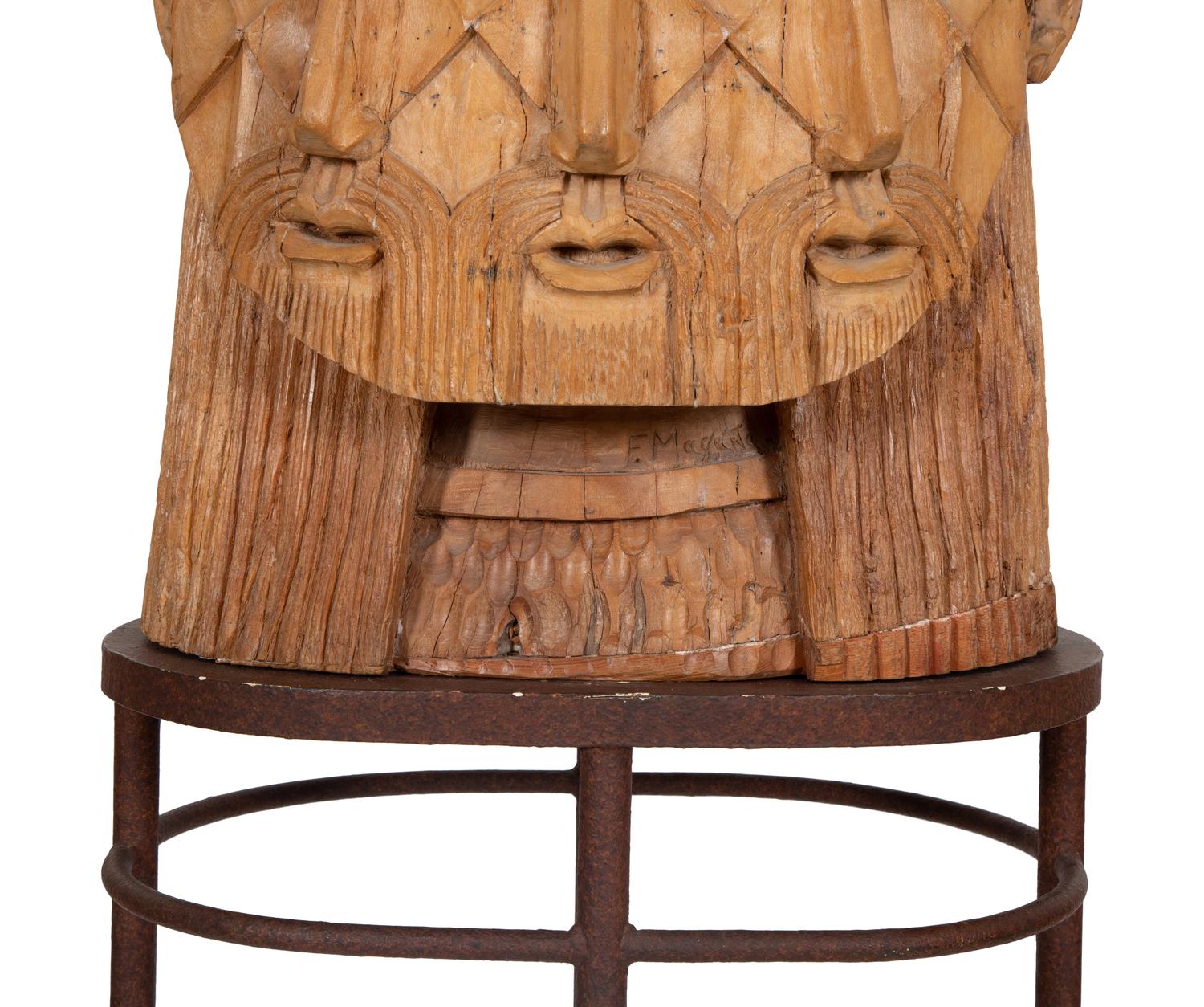 A Carved Wood Sculpture of a Three-Faced Man