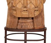 A Carved Wood Sculpture of a Three-Faced Man