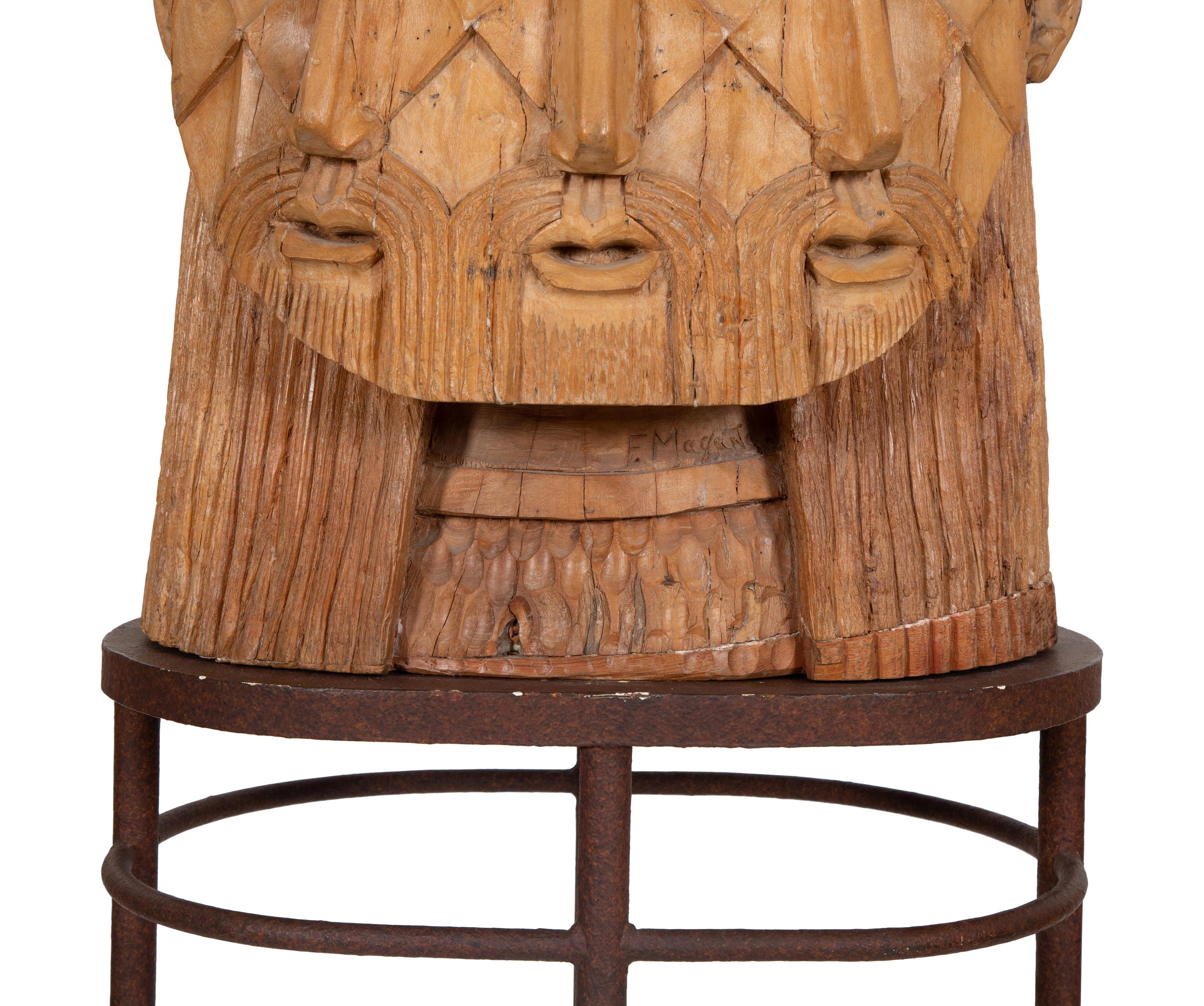 A Carved Wood Sculpture of a Three-Faced Man