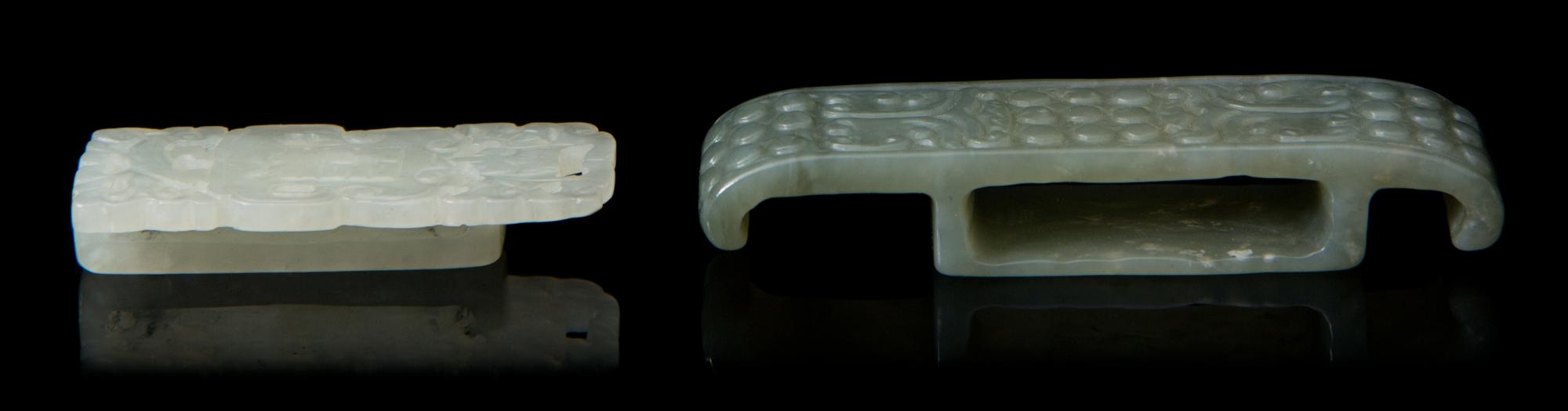 Two Carved Jade Sword Slides Length of larger 2 3/4 inches.