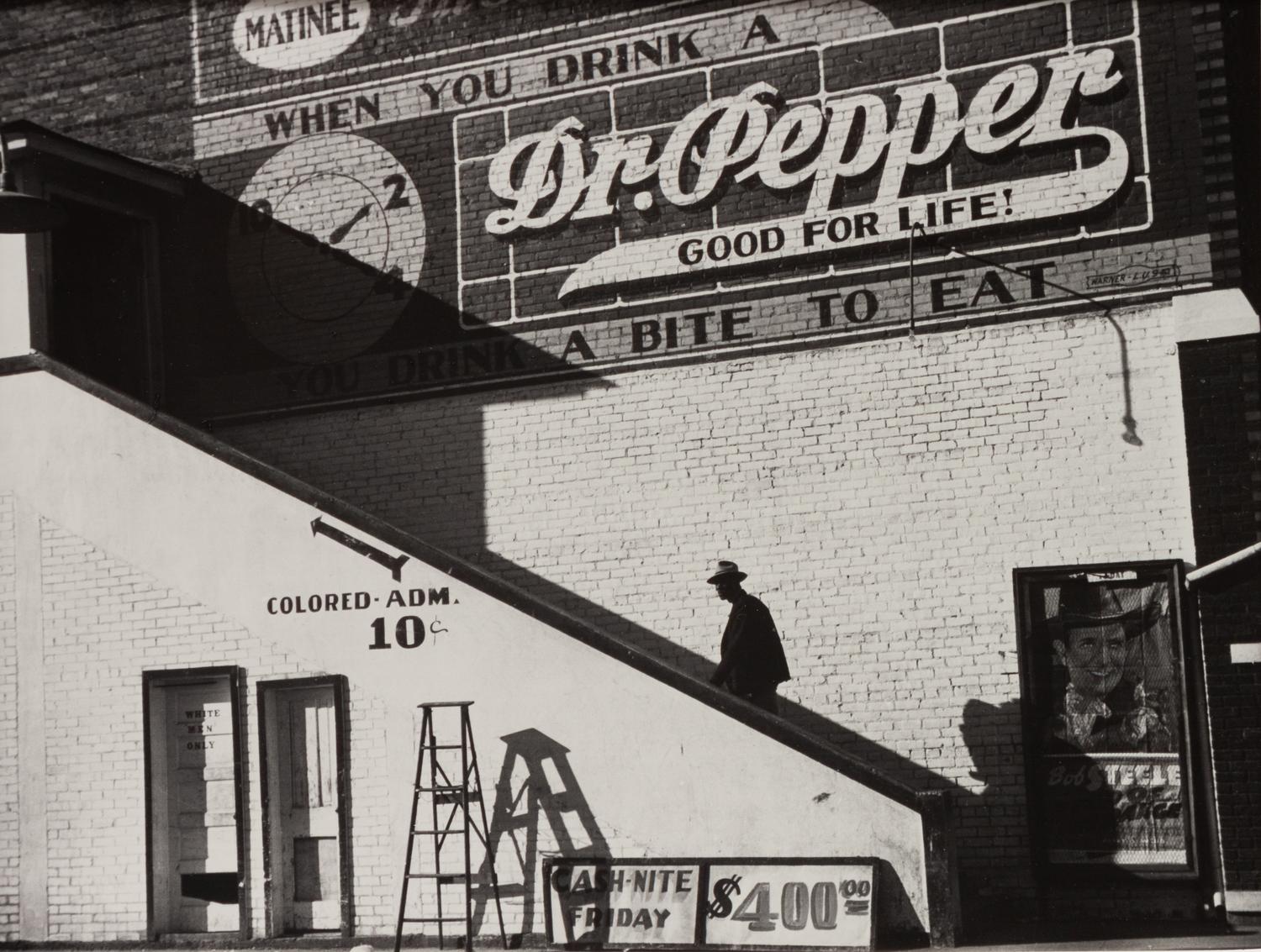 A group of five photographs ( A member of the Wilkins Family Making Biscuits , 1939; Post Office in Blizzard, Aspen, CO , 1941; Negro (Black) Man Entering Movie Theater by Colored Entrance, Belzoni, Miss., 1939; Crossroad and General Store (Mosquito Crossing) Near Greensboro, GA, 1939 (printed 1981); Recreation Evening at Community School Under Direction of WPA Recreational Supervisor (in suit and tie) Coffee County, Alabama, 1939)