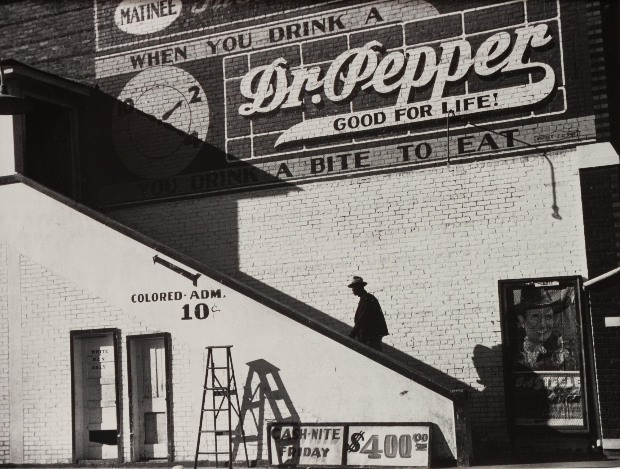 A group of five photographs ( A member of the Wilkins Family Making Biscuits , 1939; Post Office in Blizzard, Aspen, CO , 1941; Negro (Black) Man Entering Movie Theater by Colored Entrance, Belzoni, Miss., 1939; Crossroad and General Store (Mosquito Crossing) Near Greensboro, GA, 1939 (printed 1981); Recreation Evening at Community School Under Direction of WPA Recreational Supervisor (in suit and tie) Coffee County, Alabama, 1939)