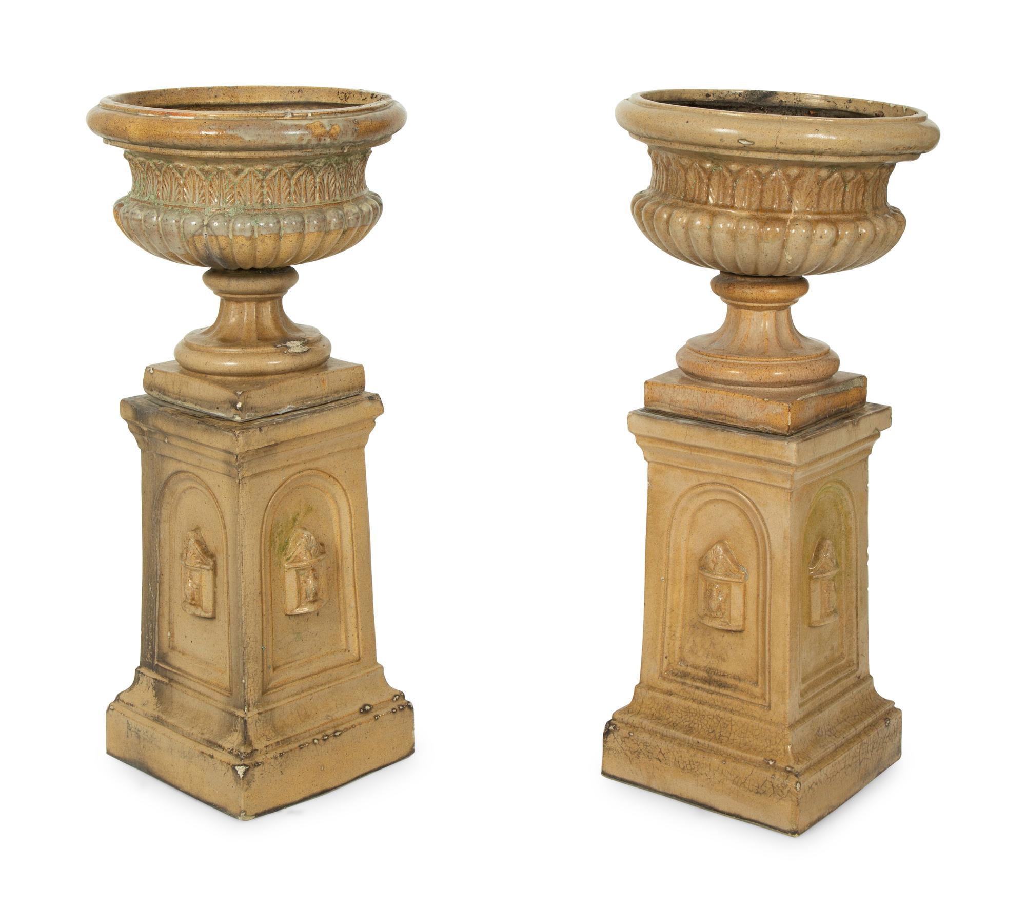 A Pair of Continental Ceramic Urns on Pedestals — EARLY 20TH CENTURY