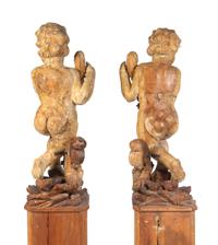 A Pair of Florentine Carved Walnut Figures of Putti on Plinths