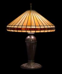 Miller Lamp Co., EARLY 20TH CENTURY, a leaded glass table lamp, having a conical geometric shade raised on an urn-form base
