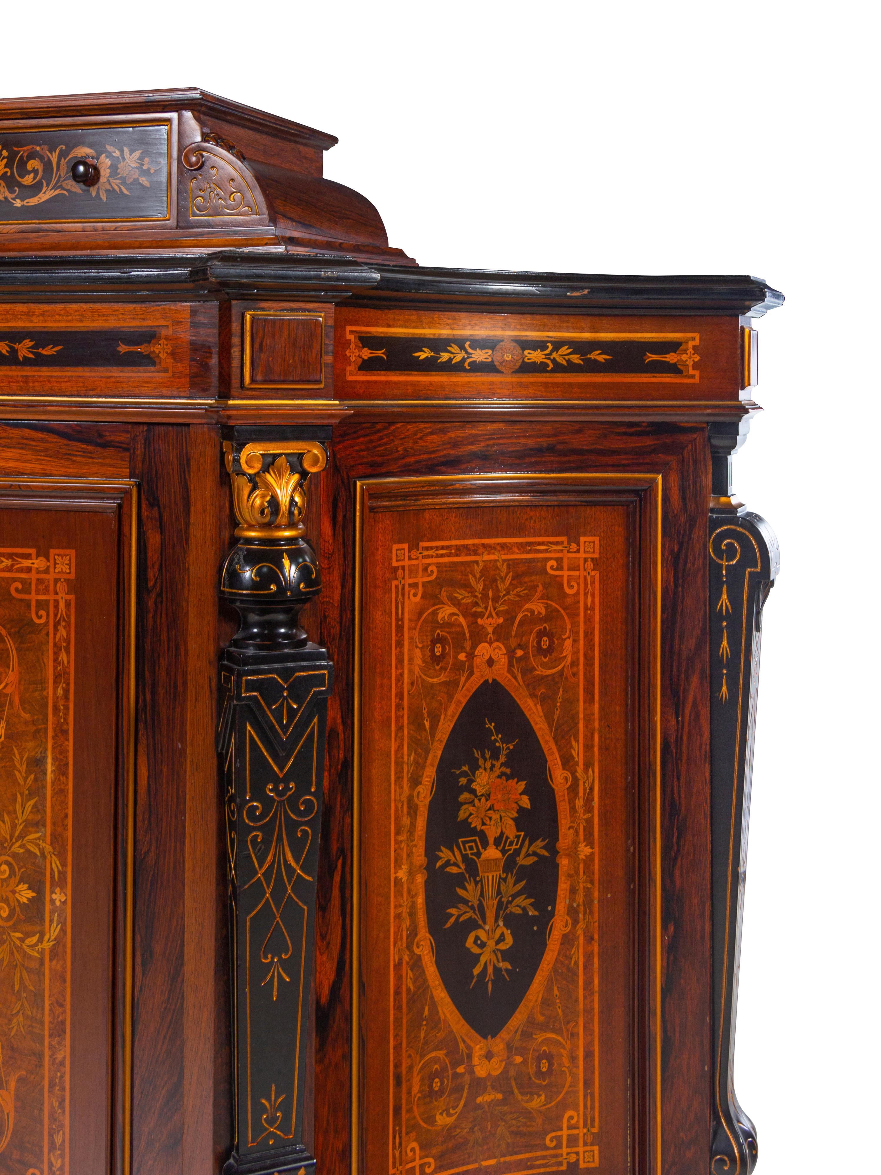 A Victorian Parcel Gilt, Ebonized and Inlaid Rosewood Parlor Cabinet
