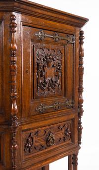 A Gothic Revival Carved Oak Cabinet on Stand