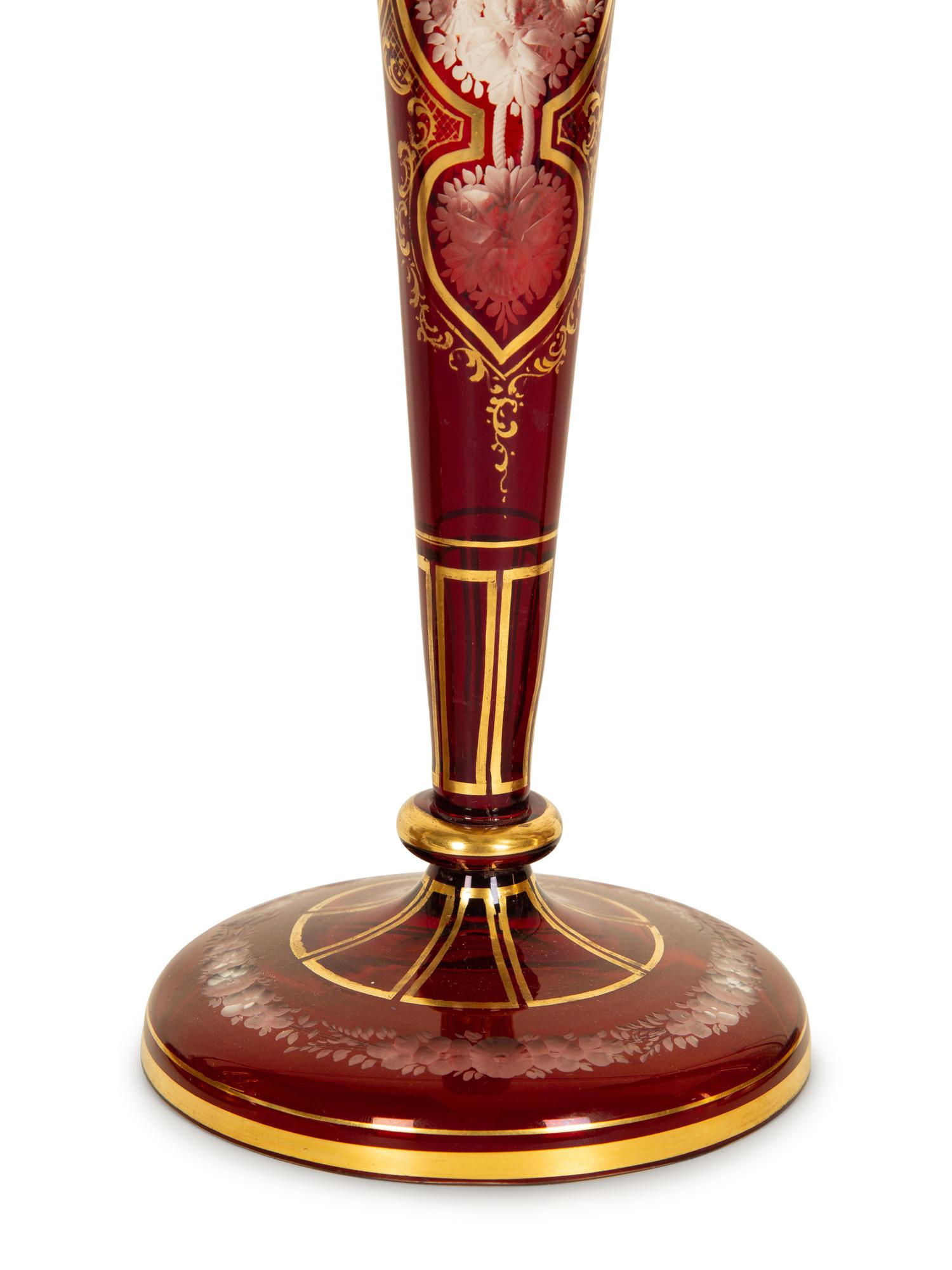 A Set of Four Bohemian Ruby Cut-to-Clear Glass Candlesticks with Gilt Decoration. — 19th Century