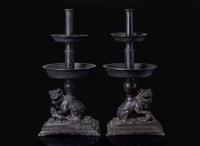 A pair of Chinese lion-form patinated bronze candle sticks, Qing dynasty, possibly Kangxi period 獅形銅加漆燭臺一對 清 可能為康熙