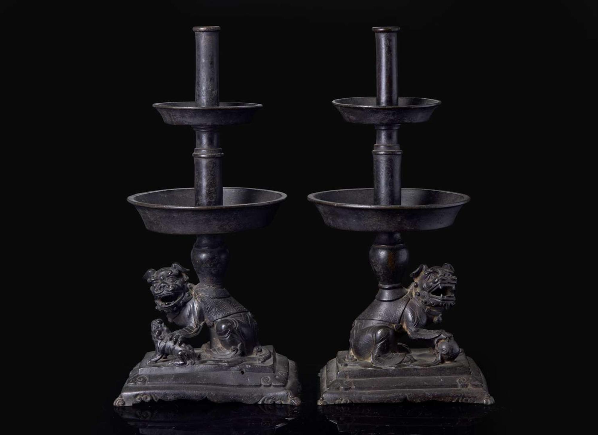 A pair of Chinese lion-form patinated bronze candle sticks, Qing dynasty, possibly Kangxi period 獅形銅加漆燭臺一對 清 可能為康熙