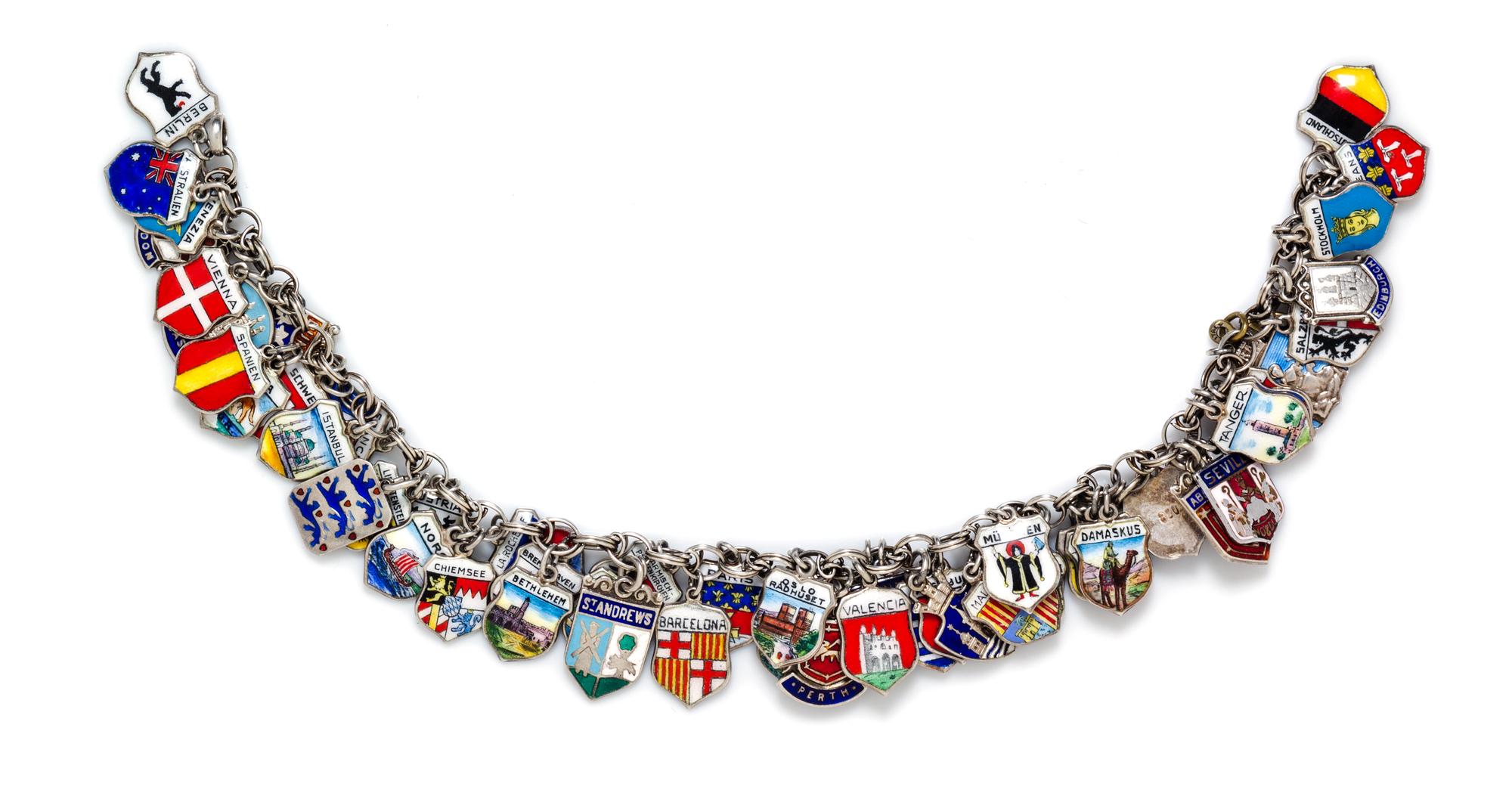 A Silver Charm Bracelet with Numerous Attached Polychrome Enamel Travel Charms, 48.20 dwts.