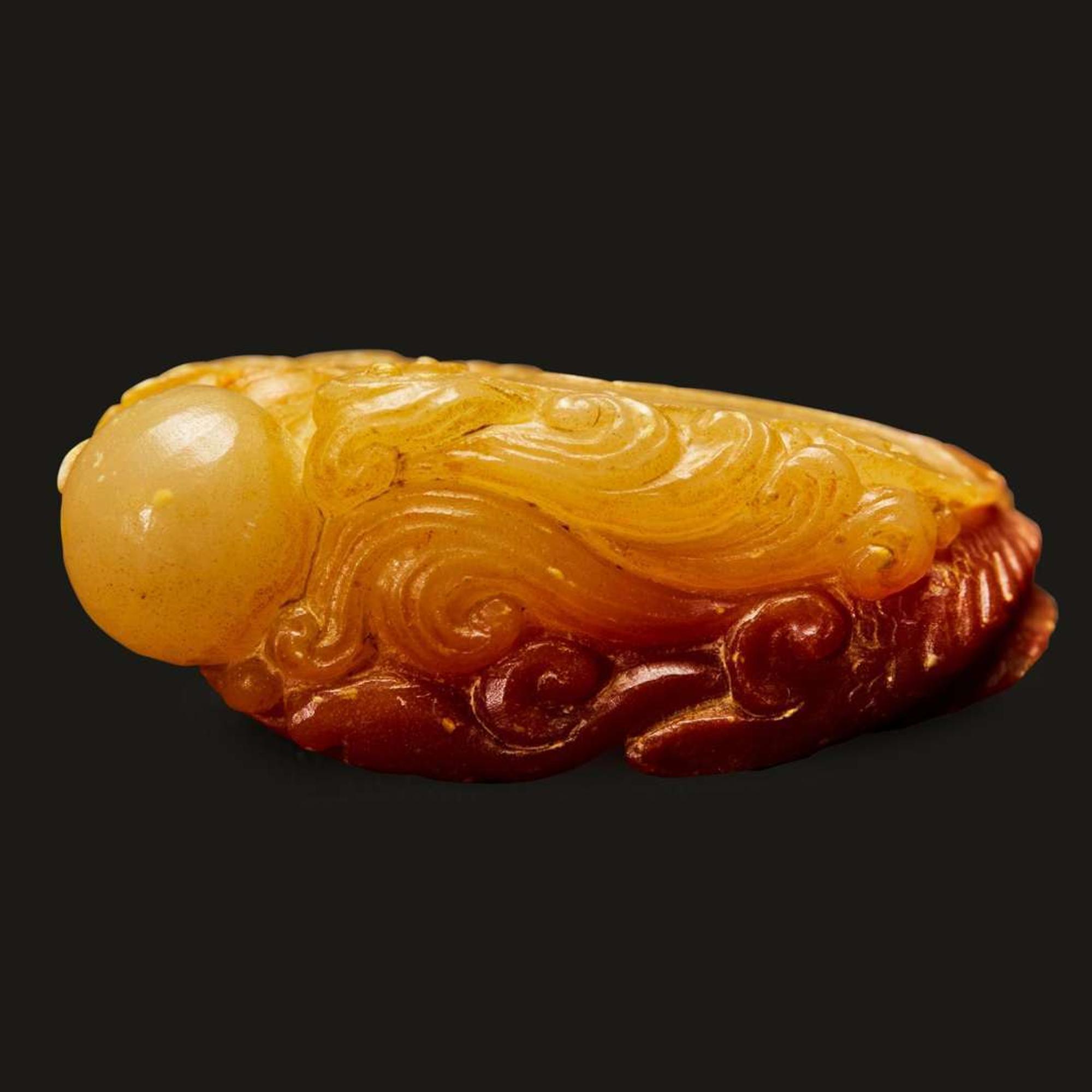 A finely-carved Chinese small yellow and russet soapstone dragon-fish, qilong, and pearl group 壽山石雕小把件