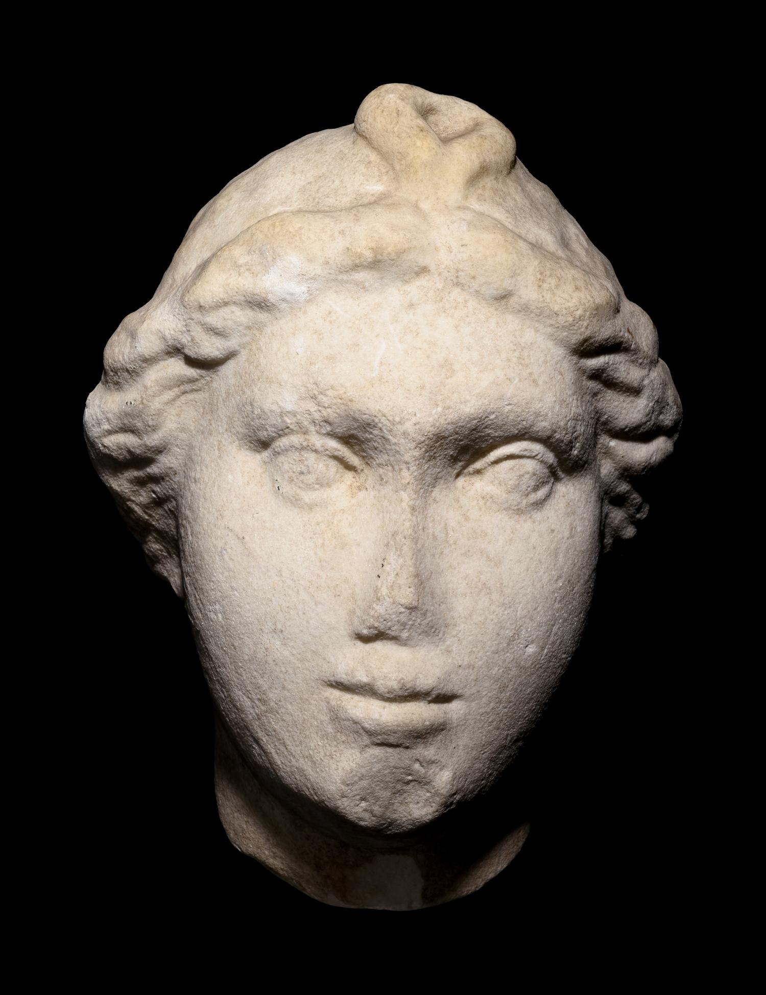 A Roman Marble Head of a Woman with Plaited Hair and Ribbon