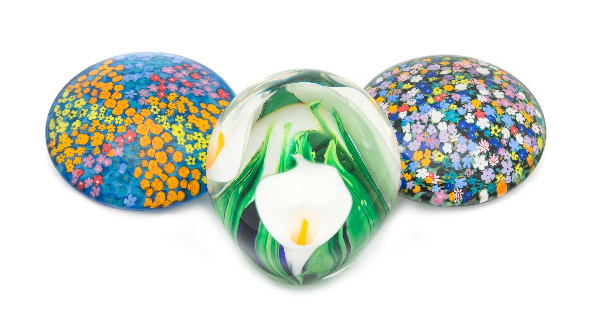 Peter Raos, (American), three glass paperweights, each with floral decoration