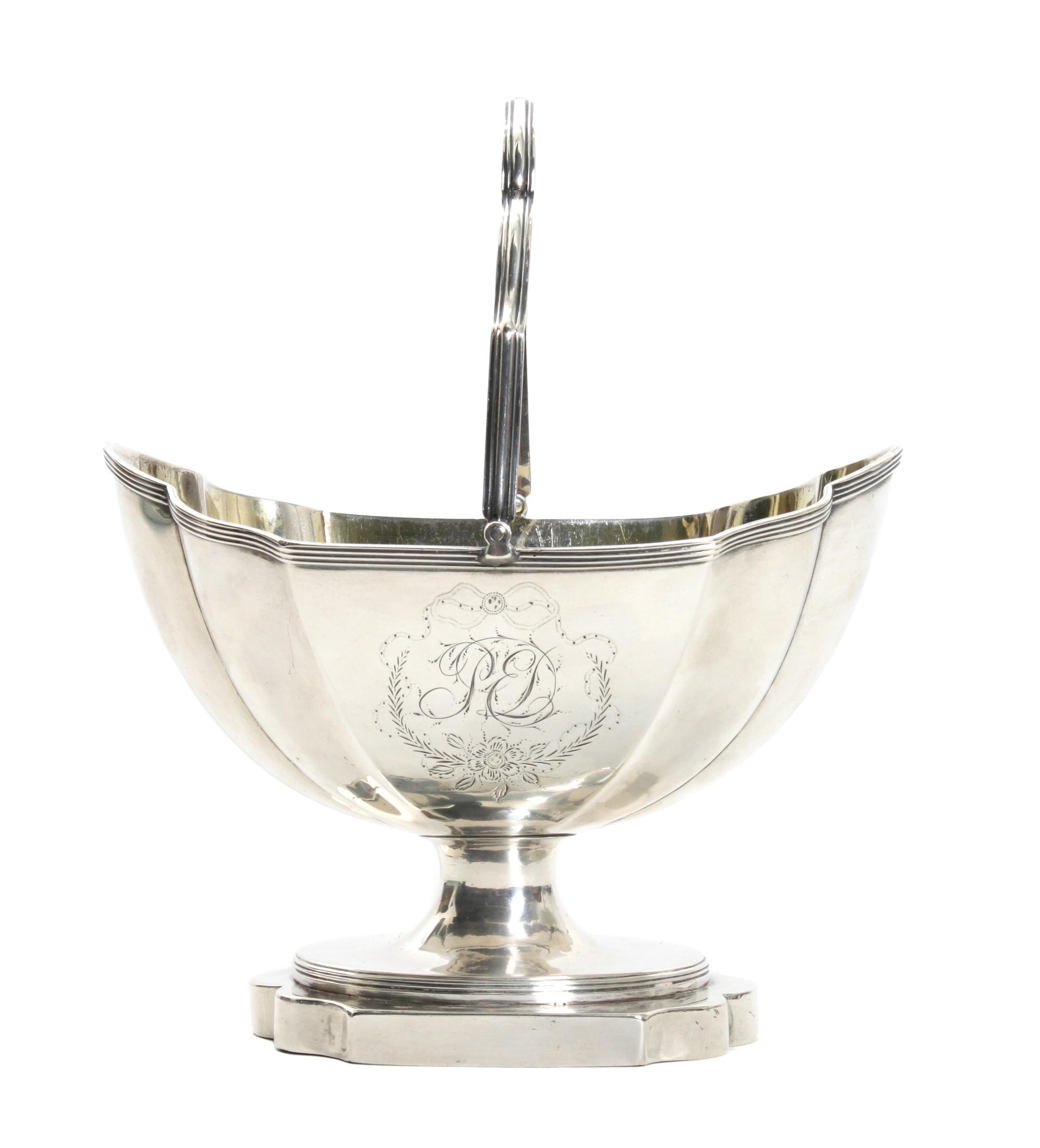 A George III Silver Sugar Basket, Henry Chawney, London, 1795, of lobed, footed form, surmounted by a swing handle, engraved with monog