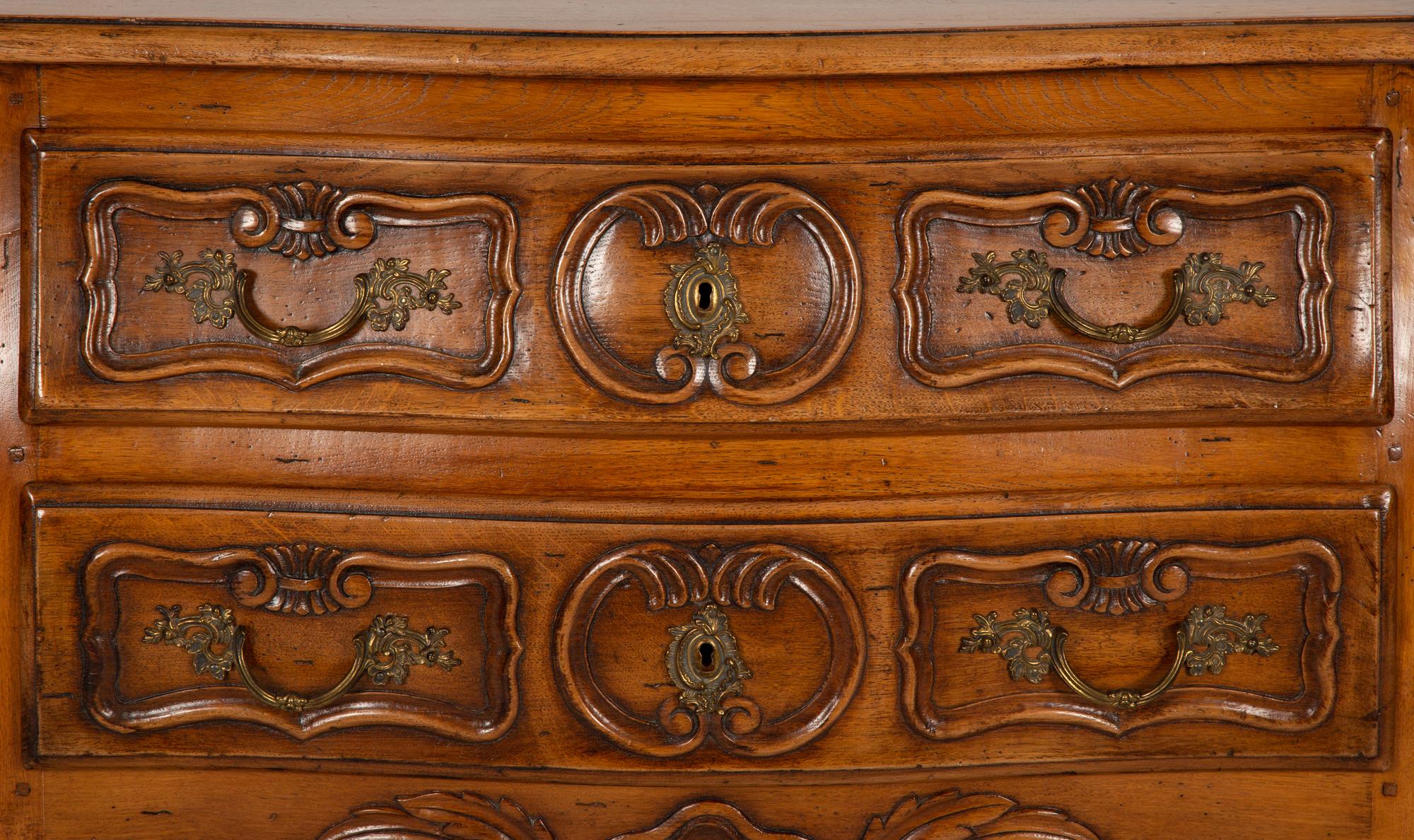 A Louis XV Provincial Style Carved Walnut Commode