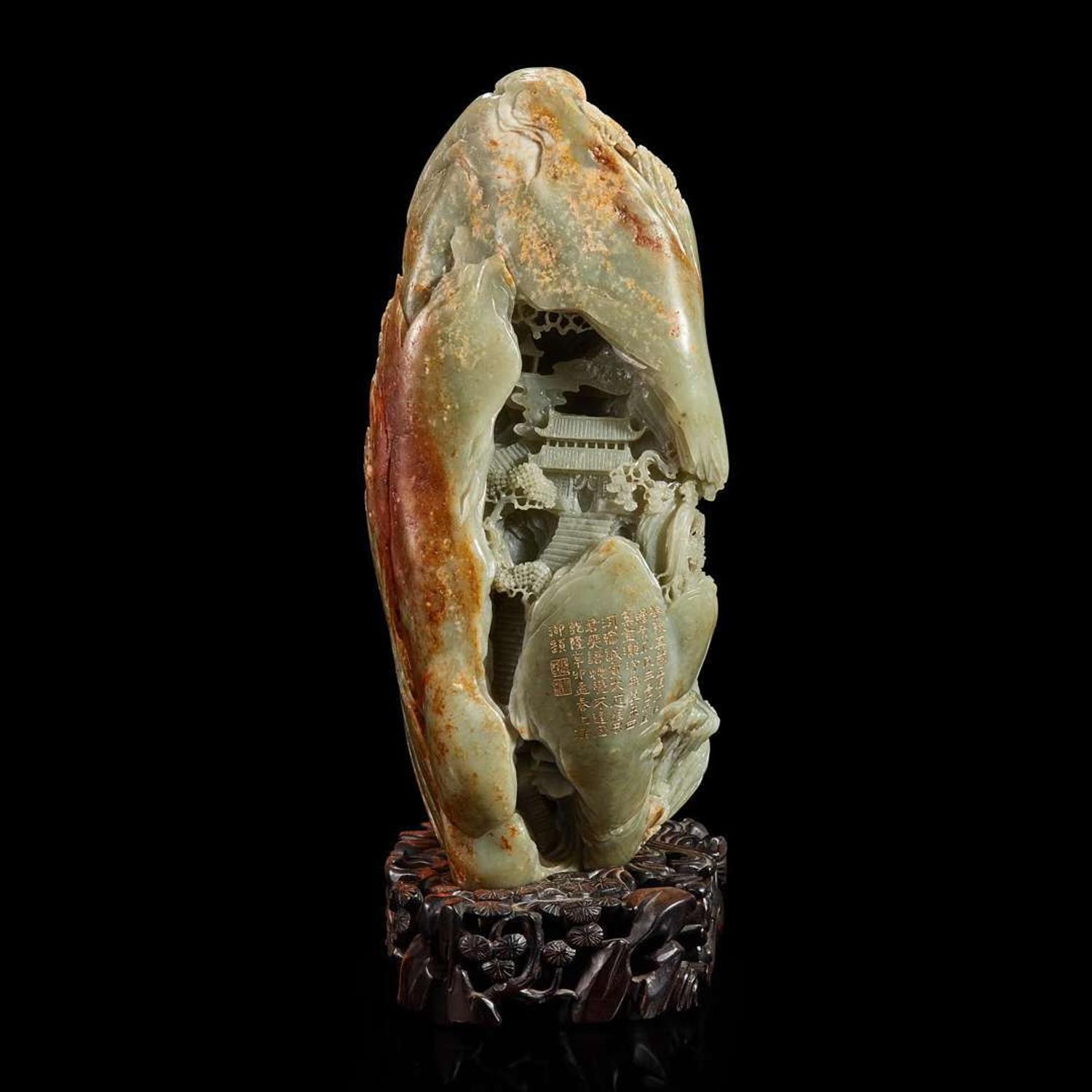 A Large Chinese carved celadon and russet jade mountain and wood stand