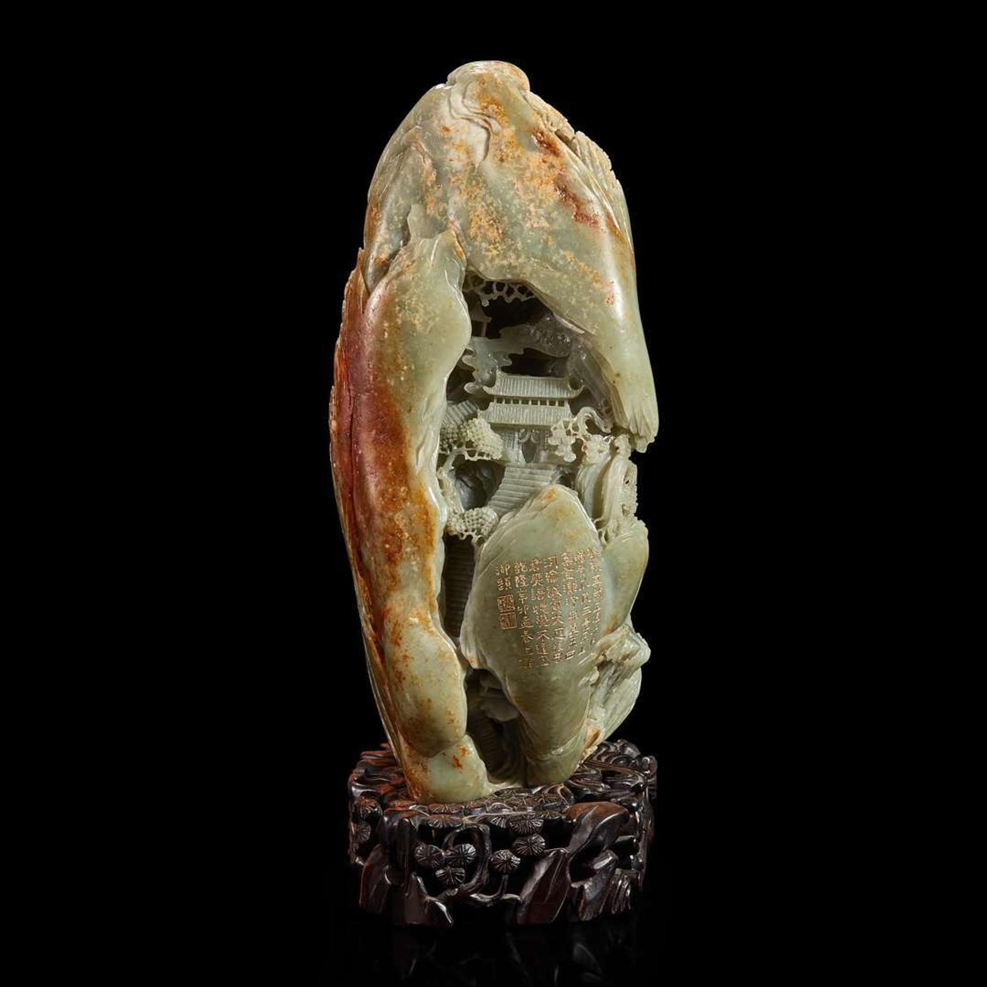 A Large Chinese carved celadon and russet jade mountain and wood stand