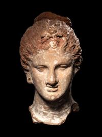 A Greek Terracotta Female Head with a Melon Coiffure