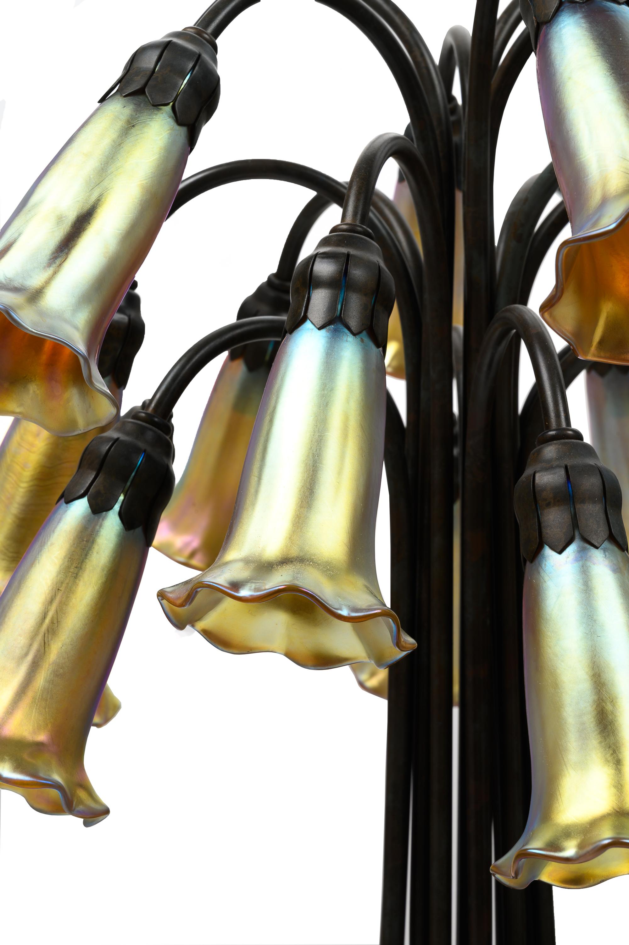 A Pair of Art Nouveau Style Patinated Metal and Iridescent Glass Eighteen-Light Tulip Lamps