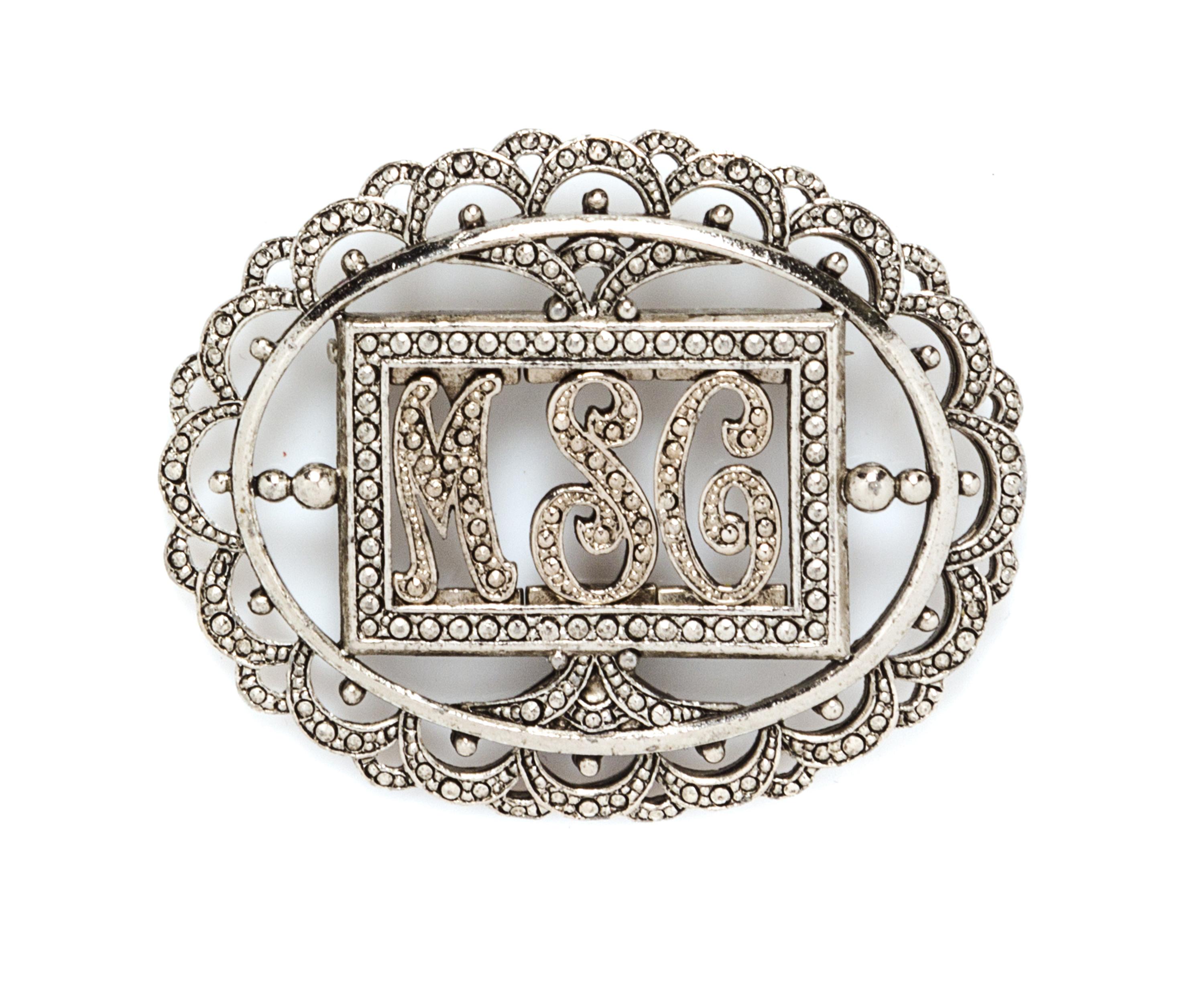 A Miriam Haskell Silvertone Monogram Oval Brooch, 2.5" x 2".