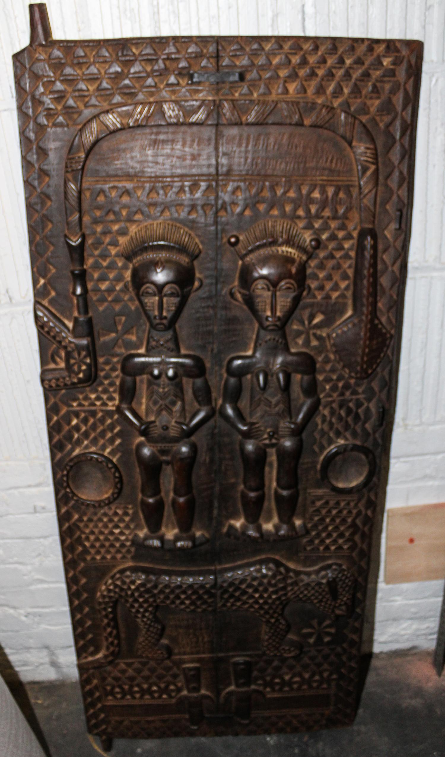 A Dogon Carved Wood Granary Door Height 56 3/4 x width 22 1/2 inches.