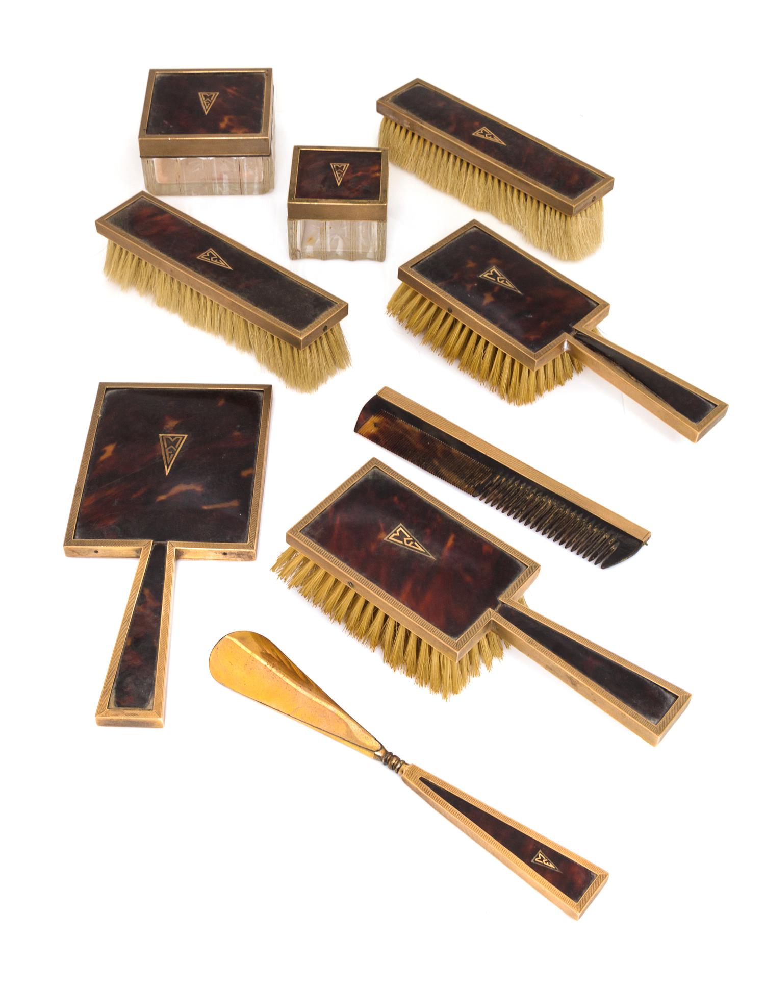 An English 9 Karat Gold Mounted Nine-Piece Dresser Set, Asprey Co., Ltd., London, Early 20th Century, having engine-turned edges, shell