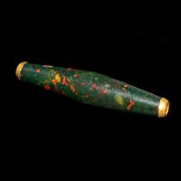 A Near Eastern Bloodstone Bead with Gold Caps