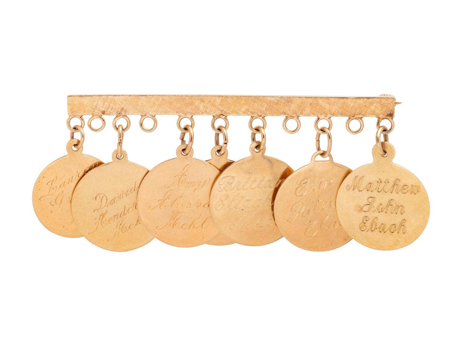 A 14 Karat Yellow Gold Charm Brooch with Seven Attached Charms,